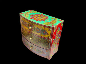 This brightly painted box features three spacious drawers, a curved front and small feet. Brass knobs as handles add a touch of elegance to our storage chest, perfect for holding everything from trinkets to jewellery and essential oils. From Rajasthan, India. Width 23.5, depth 13 cm, height 23 cm