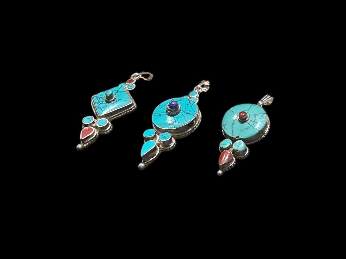 Classic Tibetan pendants, consisting of panels of turquoise and other stones set in sterling silver. These turquoise pendants are handmade in Nepal by Tibetan craftsmen.
