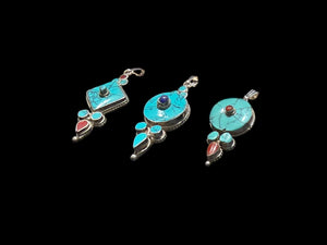 Classic Tibetan pendants, consisting of panels of turquoise and other stones set in sterling silver. These turquoise pendants are handmade in Nepal by Tibetan craftsmen.
