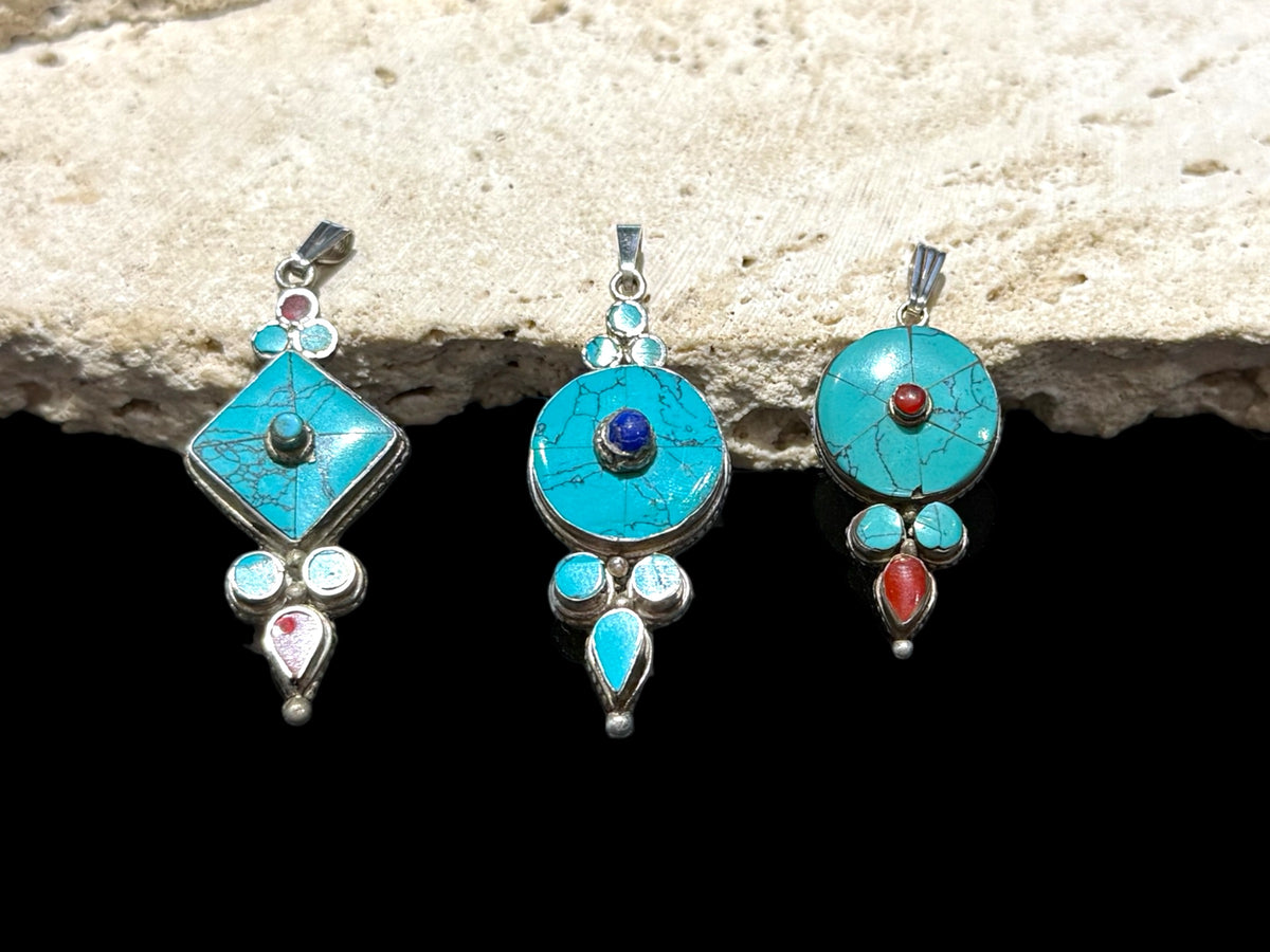 Classic Tibetan pendants, consisting of panels of turquoise and other stones set in sterling silver. These turquoise pendants are handmade in Nepal by Tibetan craftsmen.
