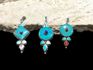 Classic Tibetan pendants, consisting of panels of turquoise and other stones set in sterling silver. These turquoise pendants are handmade in Nepal by Tibetan craftsmen.
