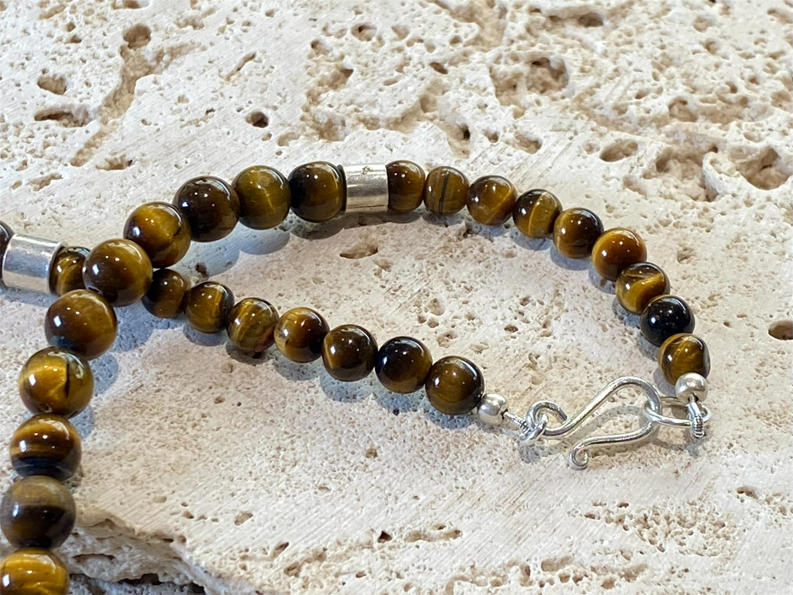 Graduated natural tigers eye necklace feature sterling silver detailing. Length 46 cm