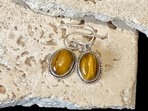 These classic oval earrings feature high quality, large cabochon cut oval tiger's eye stones set in a detailed sterling silver bezel.

Measurements: 3 cm (1.2”) length including hook