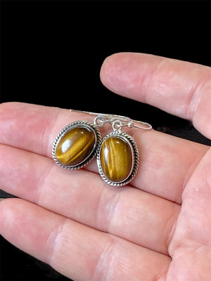 These classic oval earrings feature high quality, large cabochon cut oval tiger's eye stones set in a detailed sterling silver bezel.

Measurements: 3 cm (1.2”) length including hook