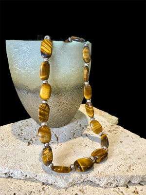 Chunky necklace featuring large pebbles of tigers eye and sterling silver rondel beads, finished with a sterling silver hook clasp. Length 48 cm