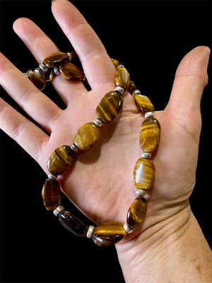 Chunky necklace featuring large pebbles of tigers eye and sterling silver rondel beads, finished with a sterling silver hook clasp. Length 48 cm