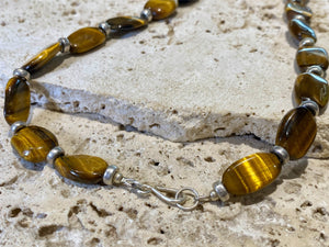 Chunky necklace featuring large pebbles of tigers eye and sterling silver rondel beads, finished with a sterling silver hook clasp. Length 48 cm