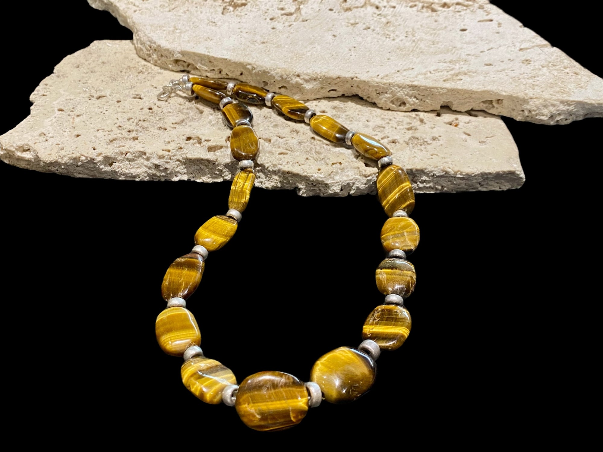 Chunky necklace featuring large pebbles of tigers eye and sterling silver rondel beads, finished with a sterling silver hook clasp. Length 48 cm