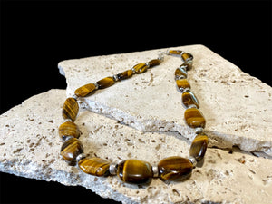 Chunky necklace featuring large pebbles of tigers eye and sterling silver rondel beads, finished with a sterling silver hook clasp. Length 48 cm