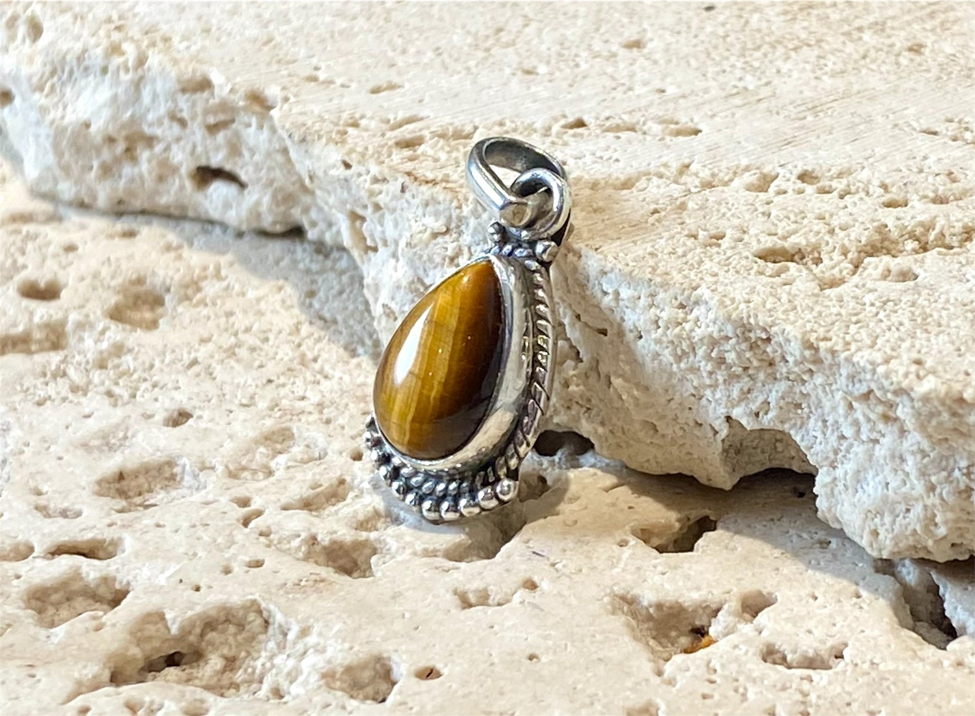 Teardrop tigers eye pendant. Set in sterling silver with a wide bail capable of taking a sizeable silver chain. Open at the back. Height including bail 2.5 cm