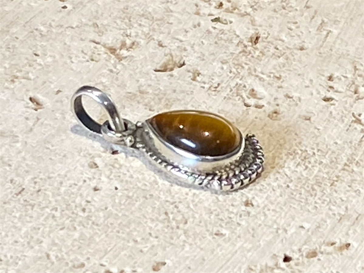 Teardrop tigers eye pendant. Set in sterling silver with a wide bail capable of taking a sizeable silver chain. Open at the back. Height including bail 2.5 cm