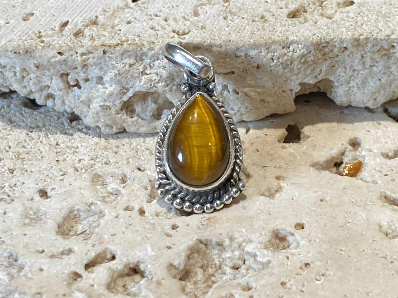 Teardrop tigers eye pendant. Set in sterling silver with a wide bail capable of taking a sizeable silver chain. Open at the back. Height including bail 2.5 cm