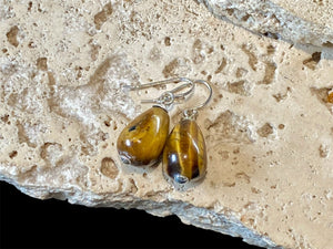 A simple earring consisting of a large teardrop of tigers eye, finished with sterling silver detailing and hooks.

Measurements: length 3 cm