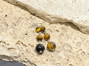 A simple, elegant earring consisting of three graduated drops of tigers eye, with sterling silver detailing and hooks.

Measurements: length 4.5 cm