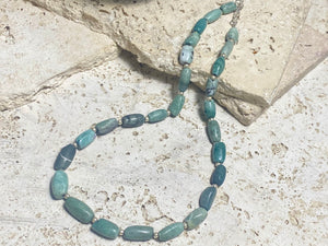 Unique necklace made up of very old natural blue green stone beads. Sterling silver spacer beads and hook clasp. This is a unisex necklace. Length 48 cm