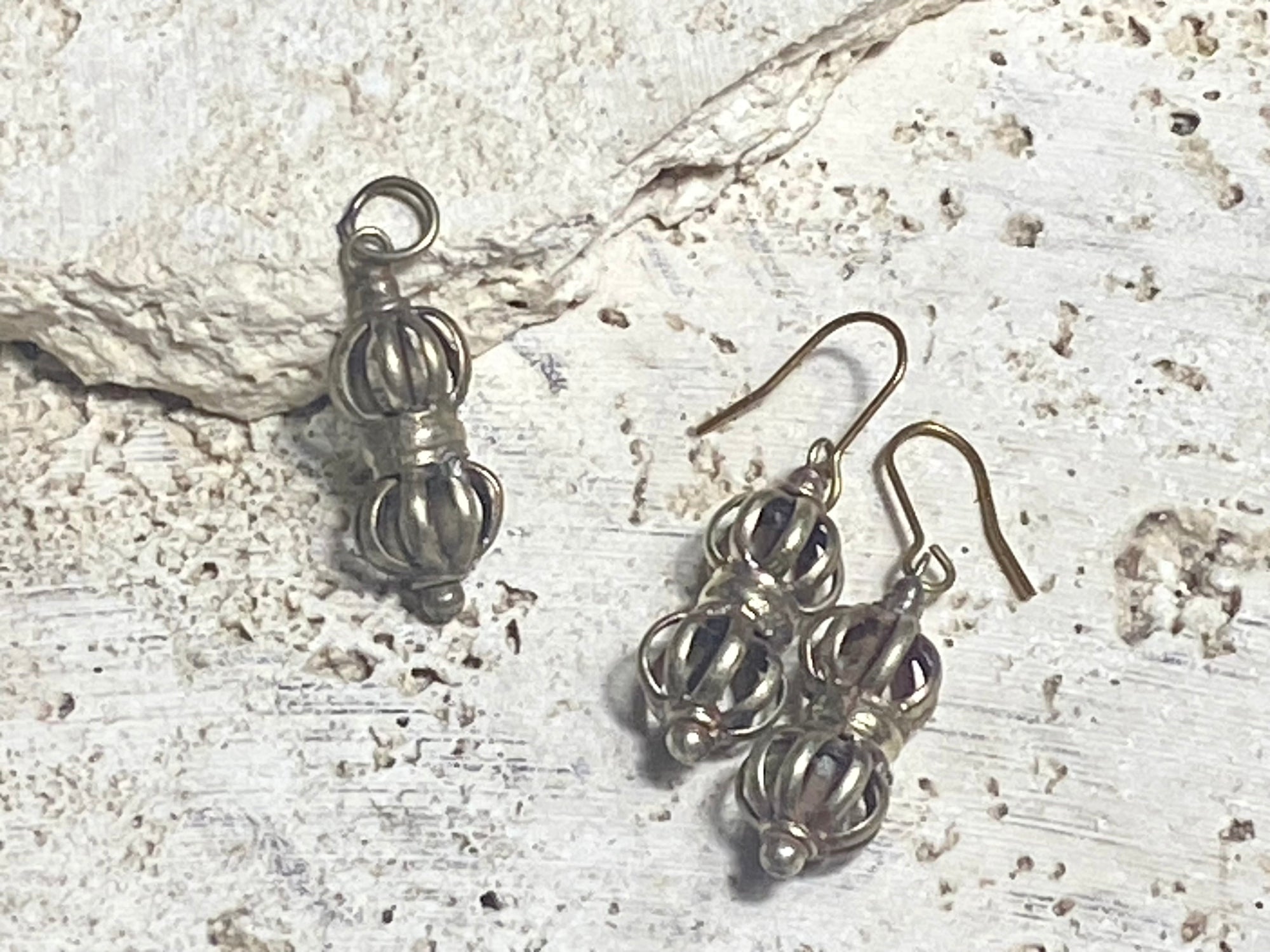 Simple dorje jewellery. Light silver/gold in colour, made from brass. Earrings feature brass hooks. Measurements: pendant height 3.3 cm, earring height 4 cm.