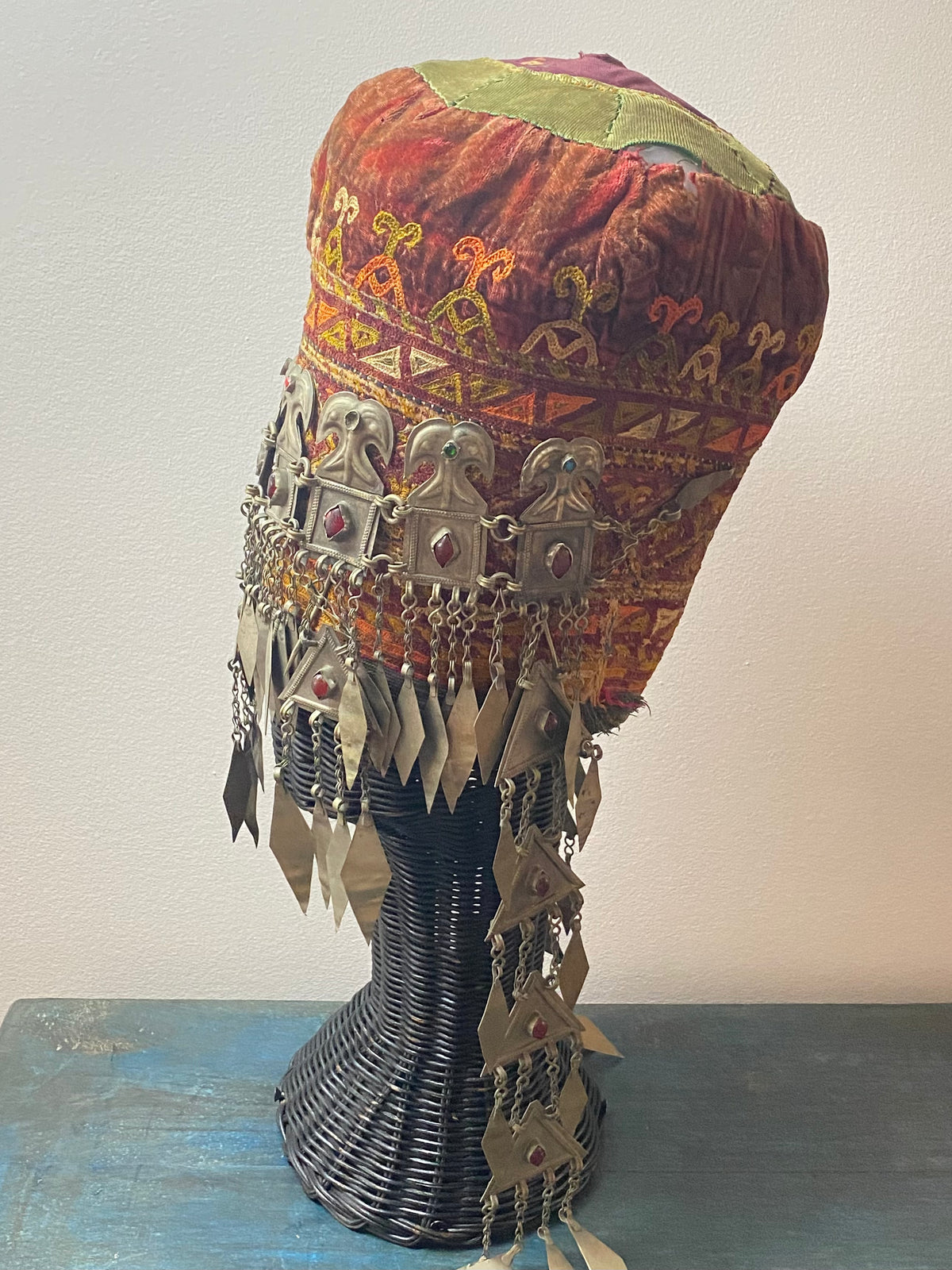 Ersari headdress consisting of a metal gaashbaagh & a high embroidered conical hat into which it attached with long spikes. The cap is quilted cotton covered in velvet and detailed silk embroidery. An heirloom piece, dating from 1870-1890. Cap height 23 cm. Tiara: width 53 cm, height of band 7 cm, side dangles 44 cm