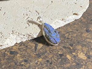 Hand carved teardrop labradorite pendant depicting Ganesh, elephant headed god of wisdom, prosperity and new beginnings. This is a unique and individual piece, with a lovely deep blue luminosity that changes depending on the angle of lighting. Sterling silver frame and bail. The bail is generous enough to allow a large chain or cord to pass through.  This unisex labradorite pendant will suit both men and women.  Measurements: height 4.2 cm including bail, width 2 cm at widest point