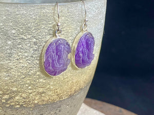 Hand carved from gem quality translucent amethyst and set in a silver surrounds and hooks, these unique earrings feature beautifully detailed images of the Hindu god Ganesh. Stunning and unique. Measurements: Drop including hooks 4 cm, width 1.5 cm