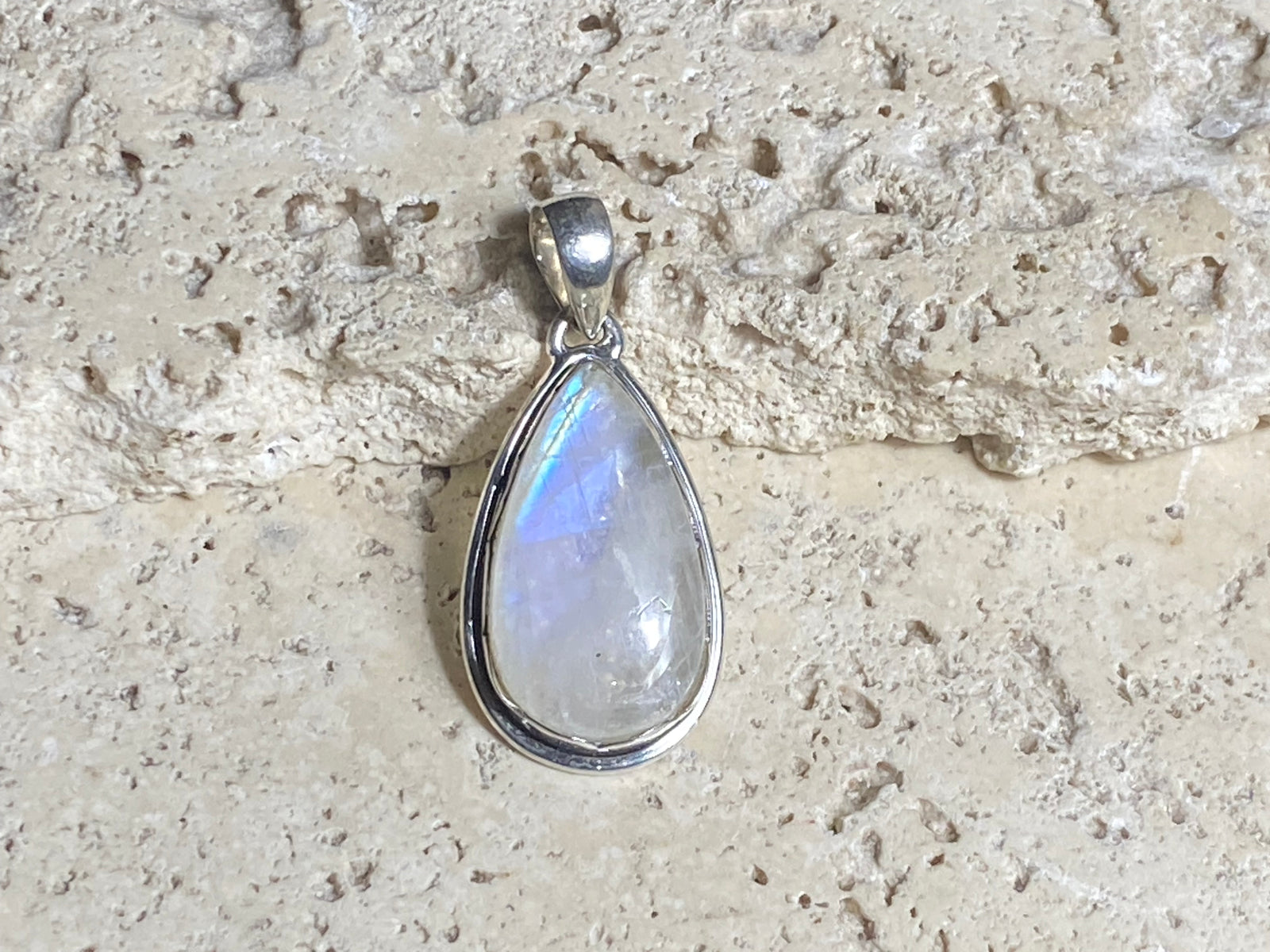 Teardrop high cut rainbow moonstone pendant set in lovely southwest style sterling silver surround with a generous bail to take a large chain or cord. A lovely stone with blue fire.&nbsp;  Measurements:&nbsp;Length including bail 4 cm, width at widest point 2 cm