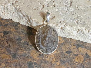 Hand carved smokey quartz pendant depicting Ganesh, elephant headed god of wisdom, prosperity and new beginnings. Sterling silver frame and bail. Measurements: height 3.1 cm including bail, width 1.8 cm. This is a unisex pendant and can be worn by men or women