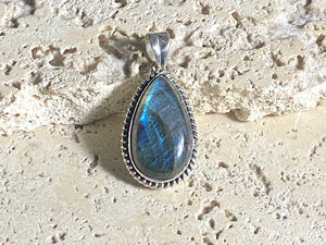 Lovely teardrop labradorite pendant set in twisted sterling silver surround with a generous bail to take a large chain or cord. A high set stone with excellent light blue colour and fire.  Measurements: Length including bail 4 cm, width at widest point 2 cm