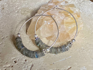 Stunning, large labradorite hoop earrings, crafted from flat labradorite stones that are facet cut on every side to show off their stunning fire and lustre. Sterling silver hoops complete the look. Measurements: 5 cm diameter