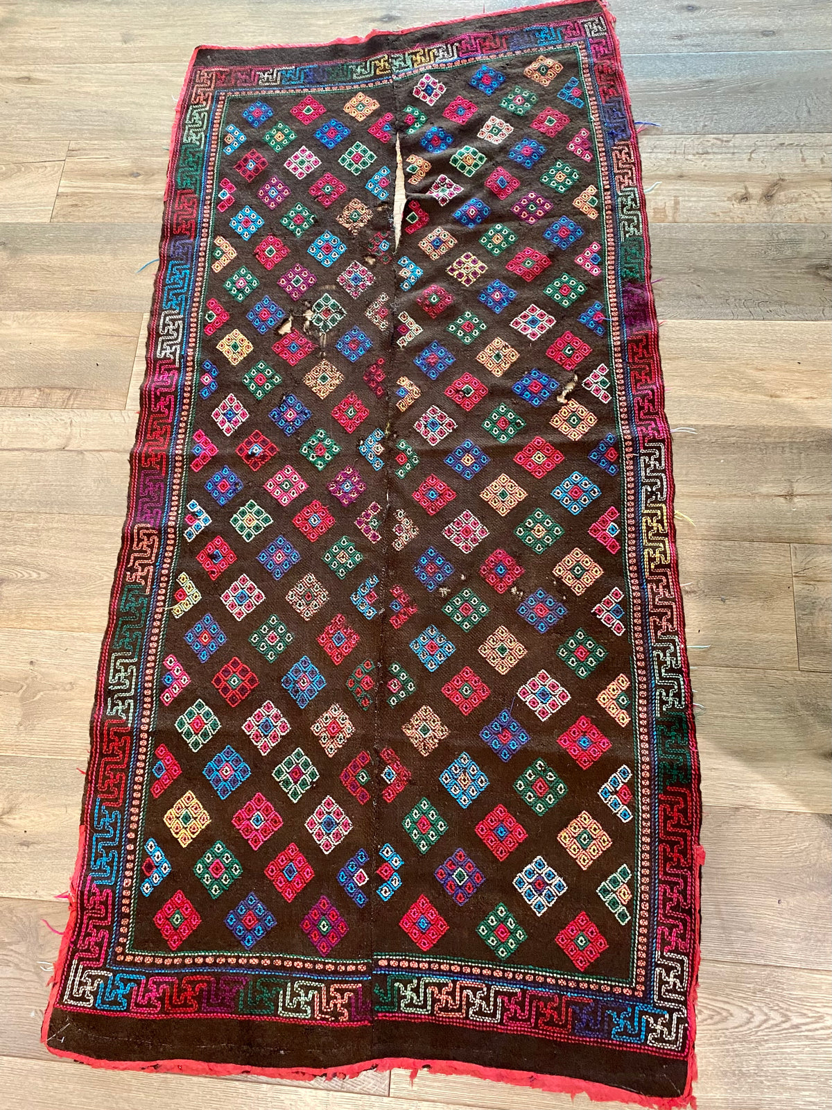 Yathra weaving, from the Chumey Valley in Bumthang, Bhutan. Hand spun and natural dyed yarn is backstrap woven into wool panels, then embroidered with wool thread. Mid 20th century. This textile is called a denkeb and was likely used as a rain cloak. Its condition is commensurate with its age. Measurements: 173 x 84 cm