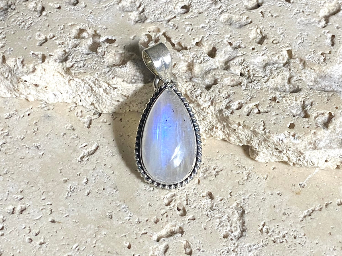 Teardrop rainbow moonstone pendant set in lovely twisted silver sterling silver surround with a generous bail to take a large chain or cord. A lovely stone with blue fire.&nbsp;  Measurements: Length including bail 3.6 cm, width at widest point 1.8 cm
