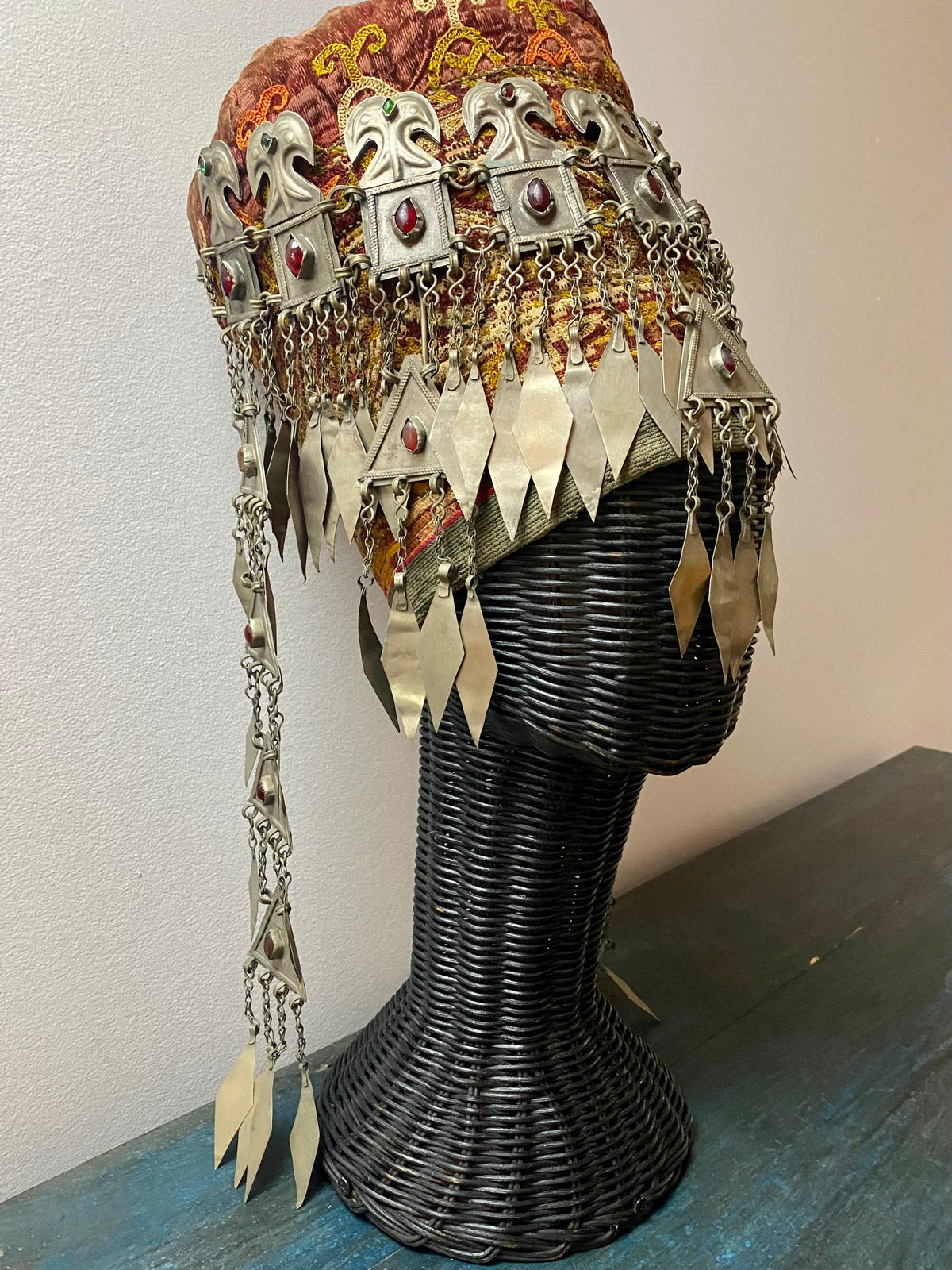 Ersari headdress consisting of a metal gaashbaagh & a high embroidered conical hat into which it attached with long spikes. The cap is quilted cotton covered in velvet and detailed silk embroidery. An heirloom piece, dating from 1870-1890. Cap height 23 cm. Tiara: width 53 cm, height of band 7 cm, side dangles 44 cm