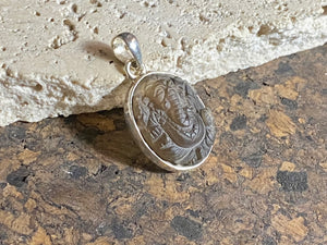 Hand carved smokey quartz pendant depicting Ganesh, elephant headed god of wisdom, prosperity and new beginnings. Sterling silver frame and bail. Measurements: height 3.1 cm including bail, width 1.8 cm. This is a unisex pendant and can be worn by men or women