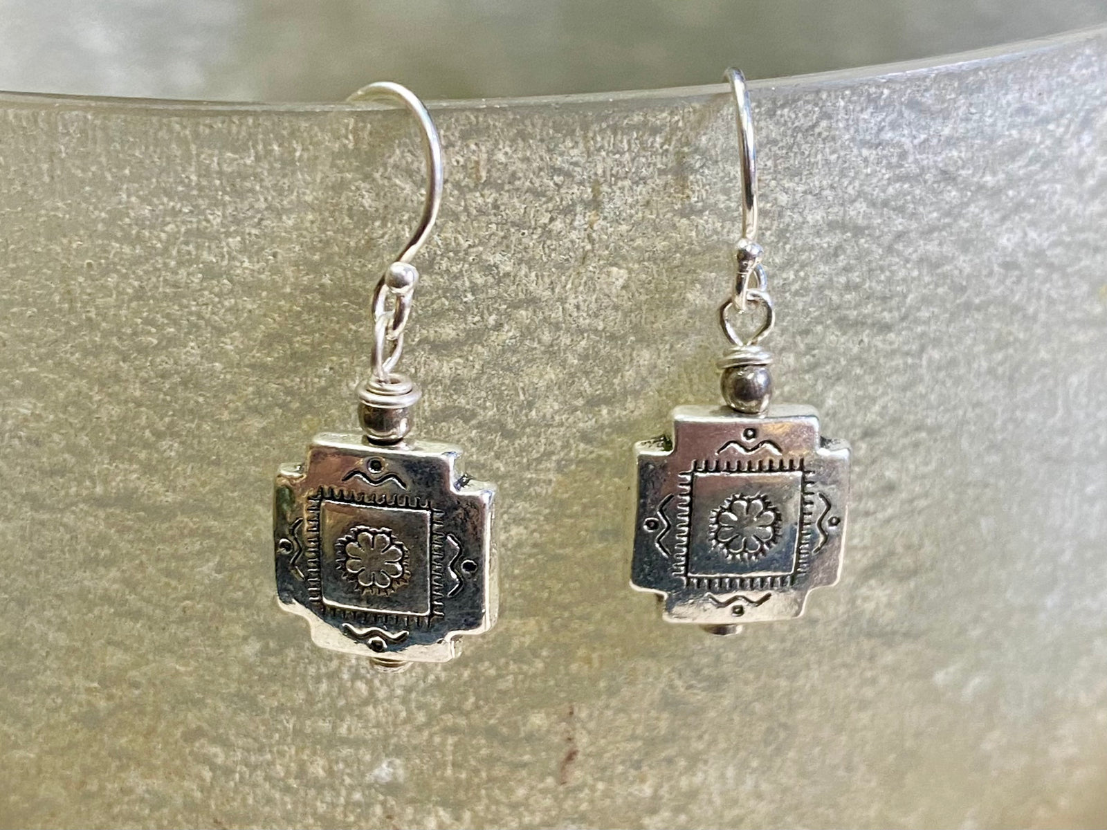 Cross earrings with a southwest vibe. The body of the earring is made from a non-tarnishing white metal indistinguishable from silver, while the other parts and hooks are sterling silver. Lightweight and easy to wear, the pattern on the earring is repeated on both sides. Measurements: drop including hook 2.5 cm