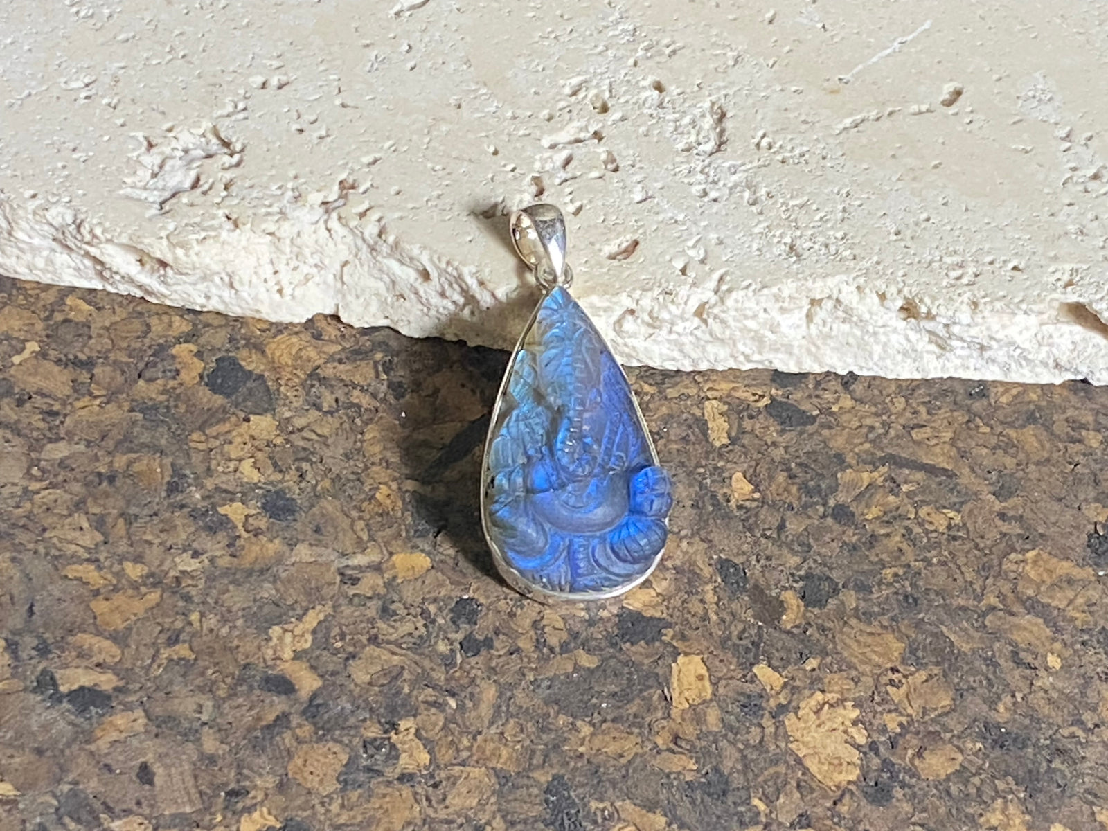 Hand carved teardrop labradorite pendant depicting Ganesh, elephant headed god of wisdom, prosperity and new beginnings. This is a unique and individual piece, with a lovely deep blue luminosity that changes depending on the angle of lighting. Sterling silver frame and bail. The bail is generous enough to allow a large chain or cord to pass through.  This unisex labradorite pendant will suit both men and women.  Measurements: height 5 cm including bail, width 2.2 cm at widest point