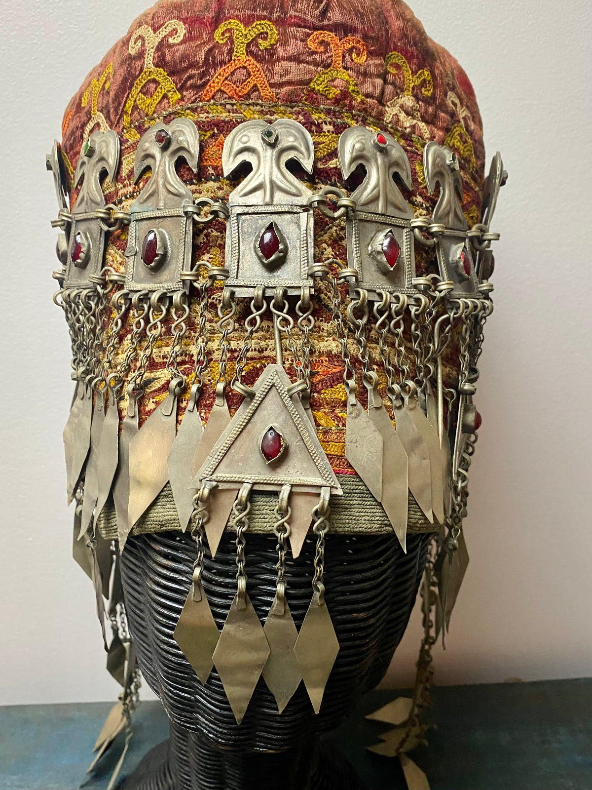Ersari headdress consisting of a metal gaashbaagh & a high embroidered conical hat into which it attached with long spikes. The cap is quilted cotton covered in velvet and detailed silk embroidery. An heirloom piece, dating from 1870-1890. Cap height 23 cm. Tiara: width 53 cm, height of band 7 cm, side dangles 44 cm