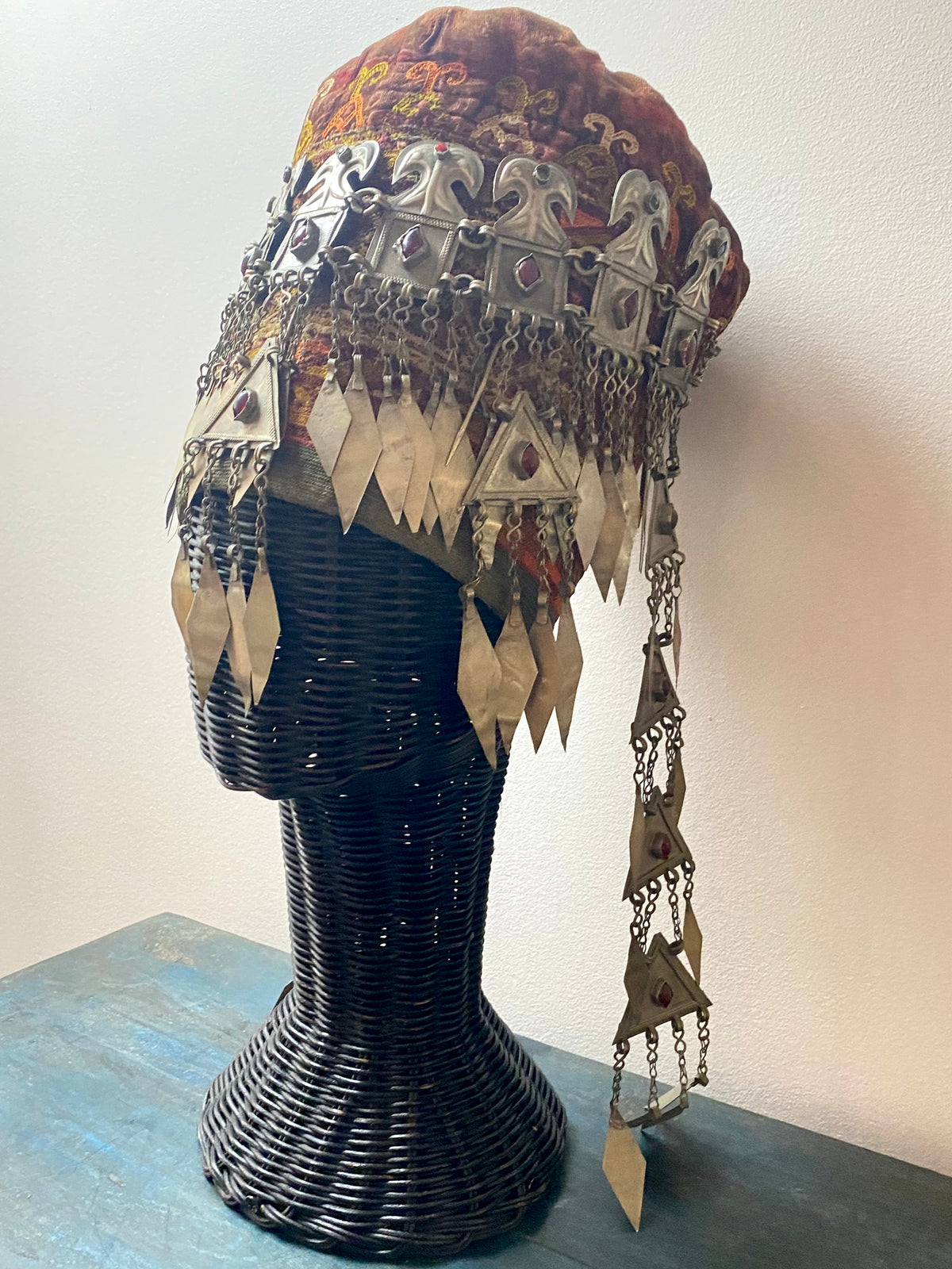 Ersari headdress consisting of a metal gaashbaagh & a high embroidered conical hat into which it attached with long spikes. The cap is quilted cotton covered in velvet and detailed silk embroidery. An heirloom piece, dating from 1870-1890. Cap height 23 cm. Tiara: width 53 cm, height of band 7 cm, side dangles 44 cm