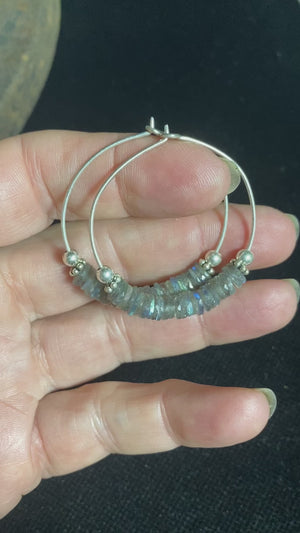 Stunning, large labradorite hoop earrings, crafted from flat labradorite stones that are facet cut on every side to show off their stunning fire and lustre. Sterling silver hoops complete the look. Measurements: 5 cm diameter