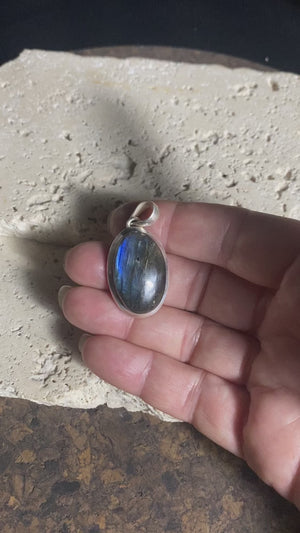 Elegant oval labradorite pendant set in sterling silver with a generous bail to take a large chain or cord. A high set stone with excellent blue colour and fire.  Measurements: Length including bail 4 cm, width at widest point 2 cm