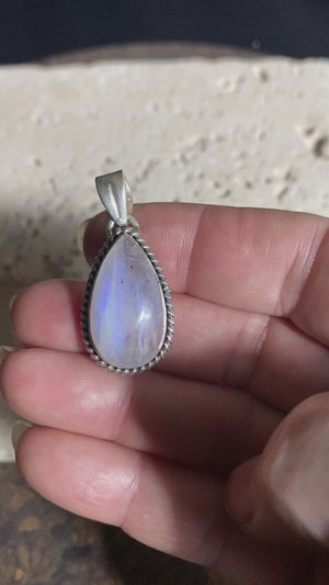 Teardrop rainbow moonstone pendant set in lovely twisted silver sterling silver surround with a generous bail to take a large chain or cord. A lovely stone with blue fire.&nbsp;  Measurements: Length including bail 3.6 cm, width at widest point 1.8 cm