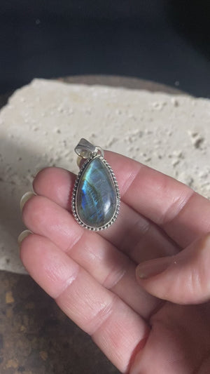 Lovely teardrop labradorite pendant set in twisted sterling silver surround with a generous bail to take a large chain or cord. A high set stone with excellent light blue colour and fire.  Measurements: Length including bail 4 cm, width at widest point 2 cm