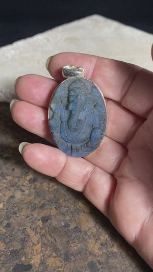 Hand carved labradorite pendant depicting Ganesh, elephant headed god of wisdom, prosperity and new beginnings. This is a unique and individual piece, with a deep blue luminosity enhanced by the depth of the stone, that changes depending on the angle of lighting. Sterling silver frame and bail. The bail is generous enough to allow a large chain or cord to pass through.  This unisex labradorite pendant will suit both men and women.  Measurements: height 5.2 cm including bail, width 3 cm