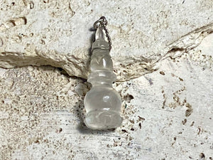 Hand carved rock crystal stupa pendant. Top mounted sterling silver bail. From Nepal. Measurements: height 5 cm