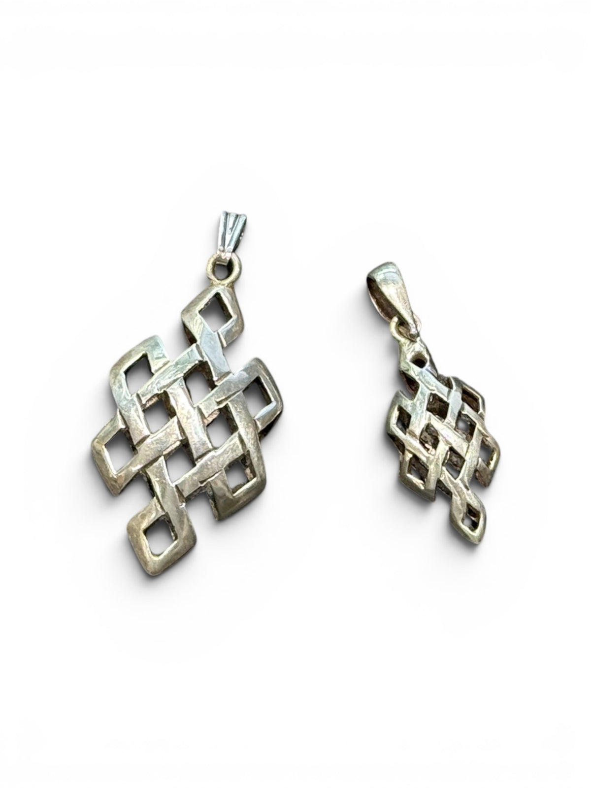 Striking silver Endless Knot pendants, one of the eight auspicious symbols of Buddhism. Sterling silver, in two sizes. 