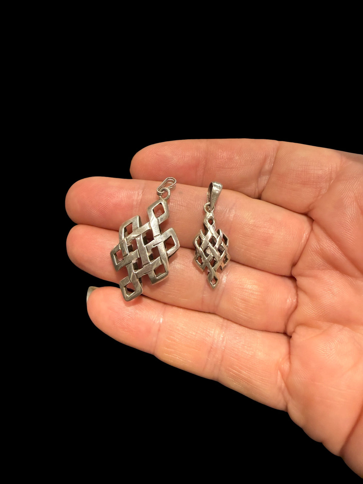 Striking silver Endless Knot pendants, one of the eight auspicious symbols of Buddhism. Sterling silver, in two sizes. 
