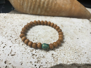 Sandalwood Buddha bracelet. Women or men’s bracelet made from sandalwood features a detailed solid brass Buddha bead. On elastic cord. Our mala bracelet will fit small men's wrists, and sit well on a women's wrist. 18 cm inside circumference. Sandalwood beads are 6 mm diameter, Buddha bead is 1 cm in length