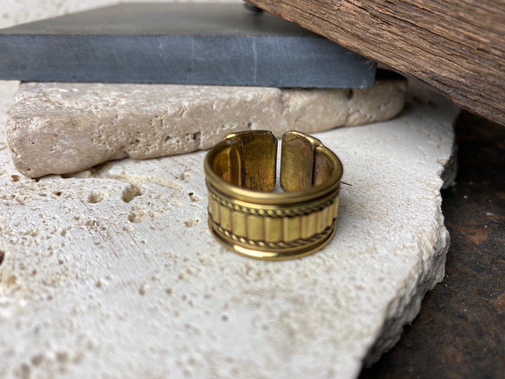 Simple brass ring with open back and a geometric design on the band. Size Q/8