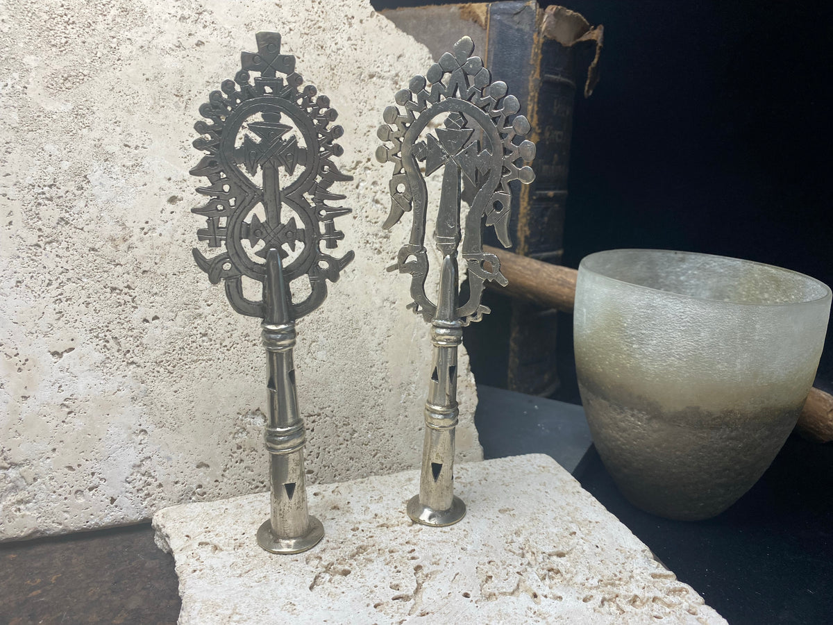 Two small Ethiopian processional crosses, hand cast by the lost wax method. Made from white metal and designed to be displayed and paraded in religious processions on top of wooden staffs, these are used vintage pieces dating to the 1970's, and are from the Lalibela region of northern Ethiopia. Height approximately 19.5 cm