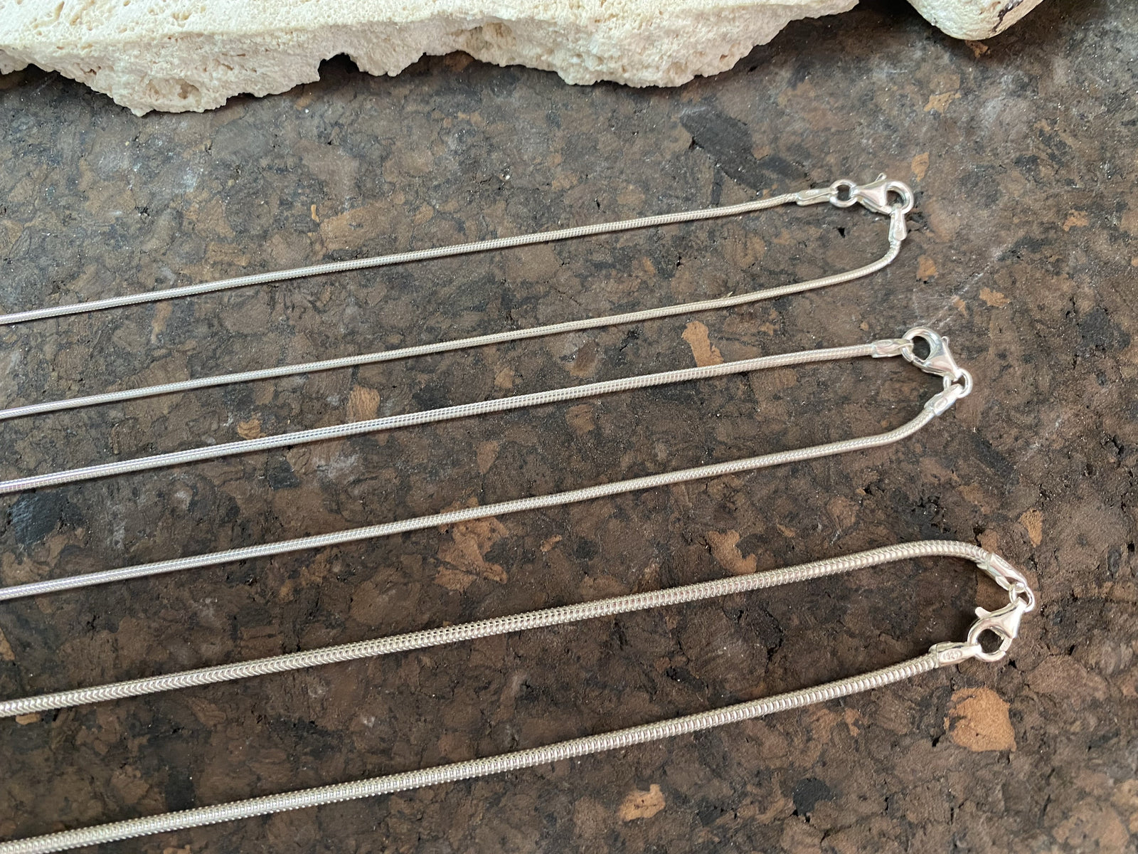 2.1 mm diameter snake chain in two lengths, these nickel-free chains are German-made from 93.5% silver and are tarnish-resistant. Our snake chain features a parrot clasp and is fitted with a narrow bail to ensure even the smallest of pendants will fit. Select Long 70 cm/28" or Very long - 80 cm/32"