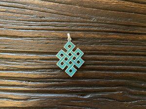 Sterling silver and turquoise Endless Knot pendant, one of the eight auspicious symbols of Buddhism. Sterling silver, set with ground chips of turquoise in enamel, from Nepal. Height 4 cm including bail