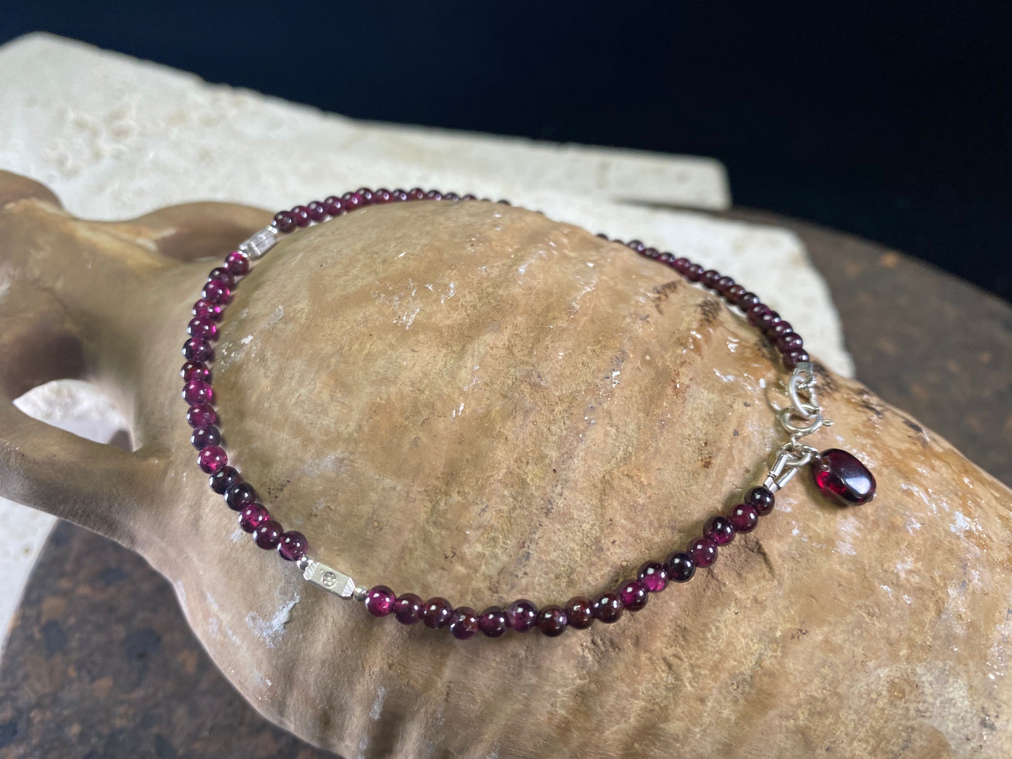 Gypsy anklets featuring natural garnet and sterling silver charms. Sterling silver clasps and detailing, with a garnet pendant that sits at the back of the anklet. Designed to sit gracefully around the foot rather than tight to the ankle. Select from three sizes