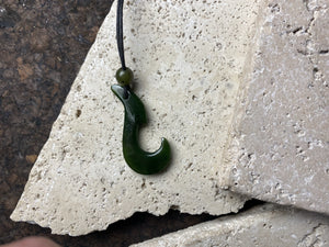 Natural green jade hei matau fish hook pendant, hand carved in New Zealand by a Maori craftsman.